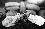 Two Girls with Pumpkins, Squash, and Watermelons