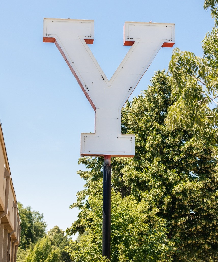 A large, white letter Y sits atop a black pole