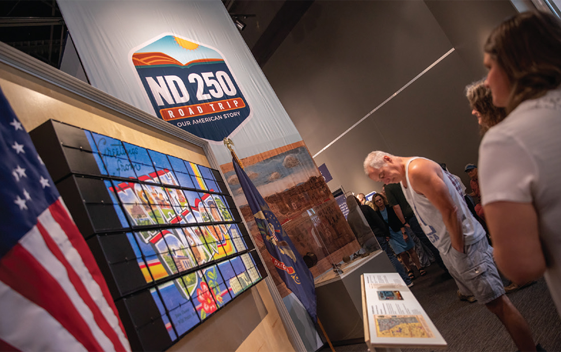 Group of people looking at new ND250 exhibit at the North Dakota Heritage Center and State Museum.